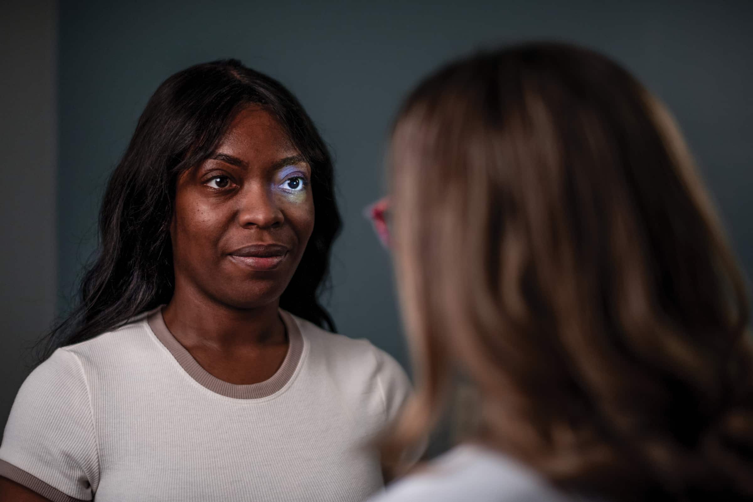 Provider holding a light up to patient's eye, checking their optic response.