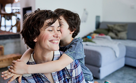 Mother and son at home, son hugging mother