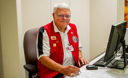 Elderly Carle volunteer working on a computer