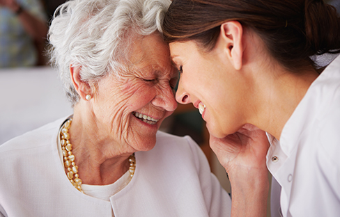 An elderly woman affectionately thanking her nurse