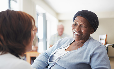 A caregiver talking to a wheelchair-bound patient