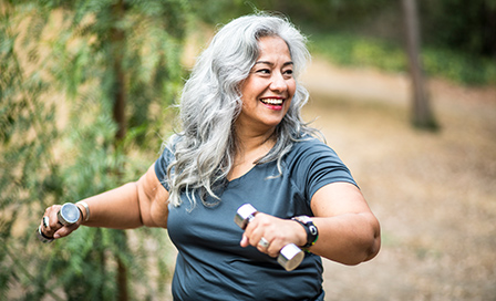 A beautiful senior Mexican Woman working out and stretching with weights