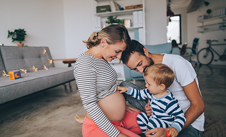 Photo of a little boy being curious about his mother's growing belly