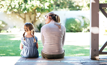 Rearview shot of a young woman and her daughter having a conversation on the porch