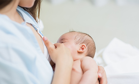 Woman breastfeeding her infant child.