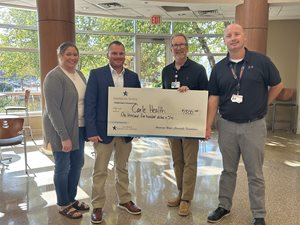 Group standing with check from grant.
