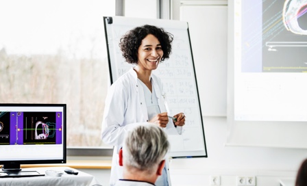 A clinical doctor smiling during a teaching session she is hosting at the hospital.