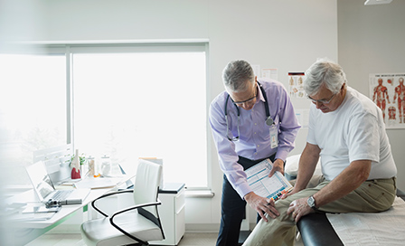 Doctor examining the knee of an elderly man