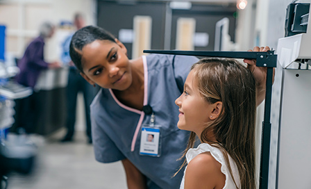 Nurse measuring height of girl